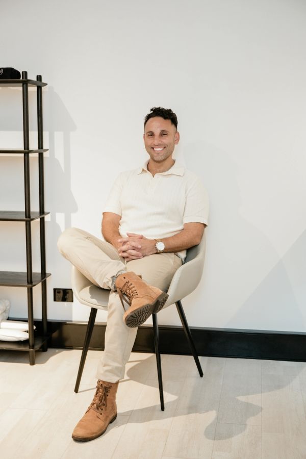 Man sitting comfortably on a chair with a smile.