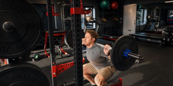 client doing high bar carry barbell back squat