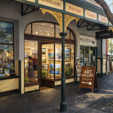 Art gallery entrance with paintings and a coffee shop sign.