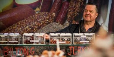 Karutz Smallgoods behind a display of packaged biltong and jerky at a market stall.