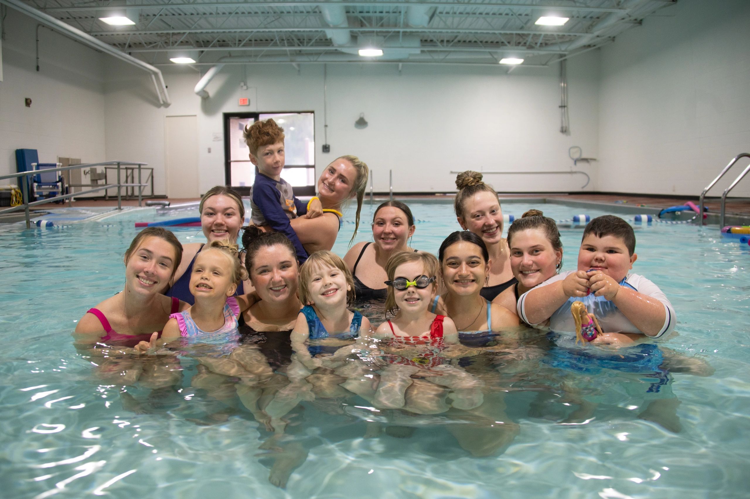 Group of people smiling in a swimming pool. 