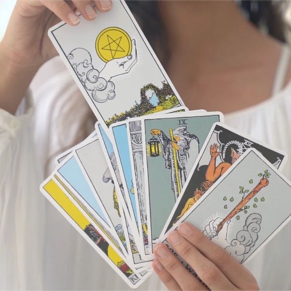 A person holding arcana tarot cards