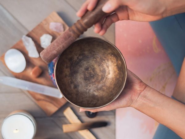 A person using singing bowls and various healing crystals.