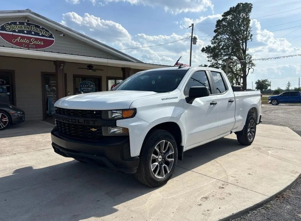 White Chevrolet Silverado parked outside Southern Country Auto Sales on a sunny day.