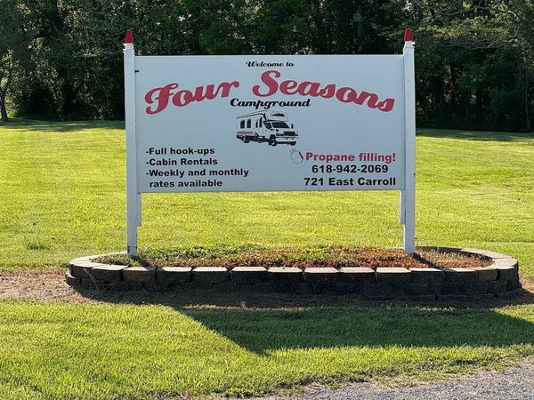 Signboard for Four Seasons Campground with services and contact details.
