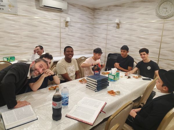 Group of young men enjoying a meal and study session together.