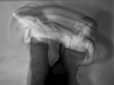 Black and white photo showing a woman in motion with blurred effects.