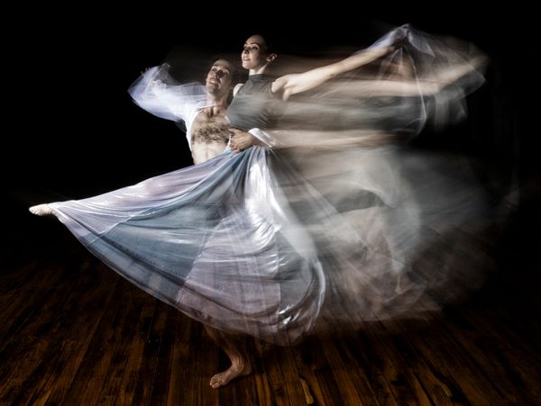Ballet dancers captured in graceful motion with flowing skirts and blurred movement.