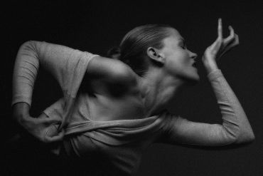 A graceful dancer captured in a striking black and white pose.