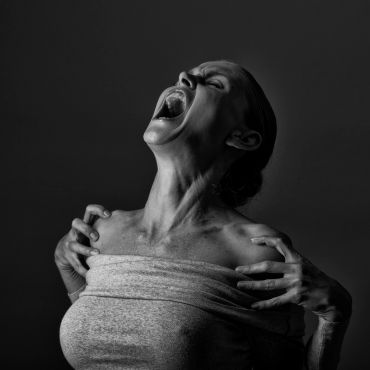 Black and white photo of a woman screaming with intense emotion.