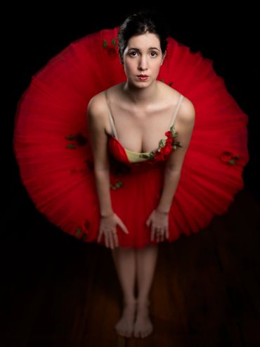 Ballerina in a red tutu looking up.