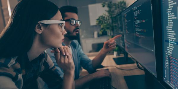 two people consult a computer screen