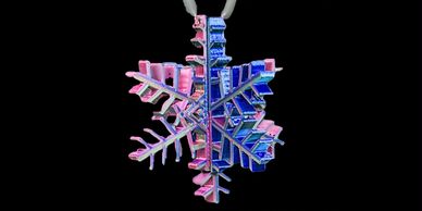 A blue and pink snowflake pendant against a black background.