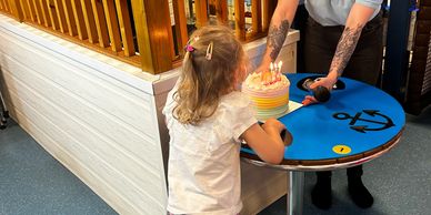 young girl blowing out her birthday cake in a kassiopi cove private hire.