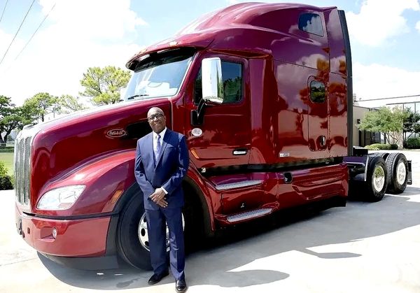Life Coach CEO Standing in front of a truck smiling