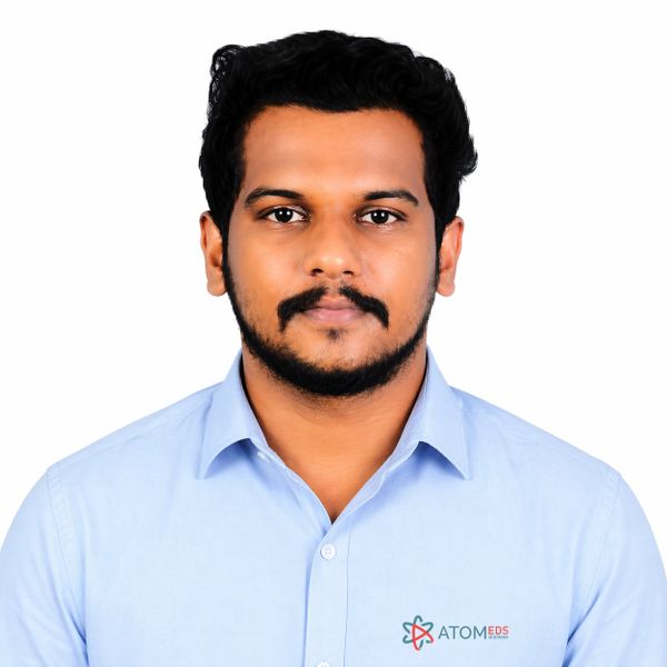 Portrait of a man in a light blue shirt with ATOMEDS logo.