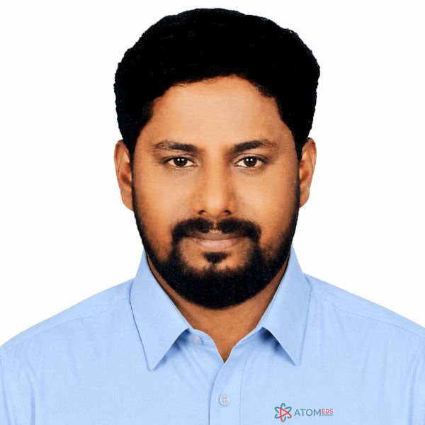 Portrait of a man with a beard wearing a light blue shirt.