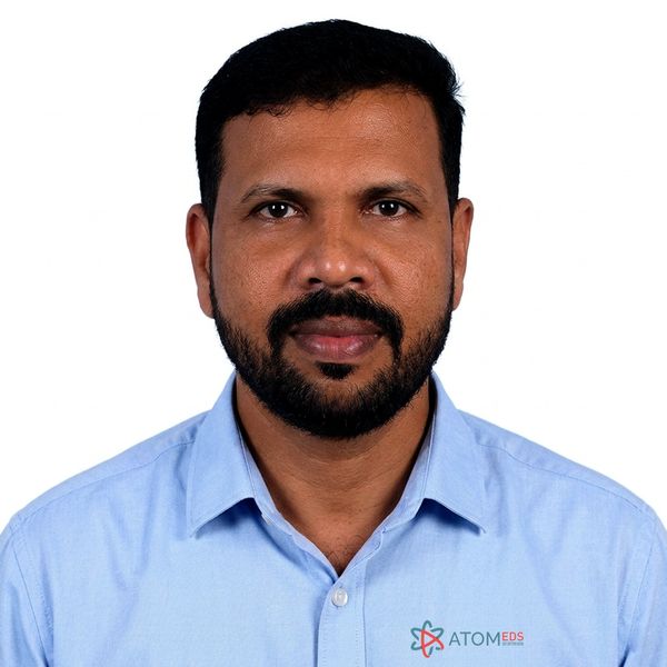 Portrait of a man in a blue shirt with ATOMEDS logo.