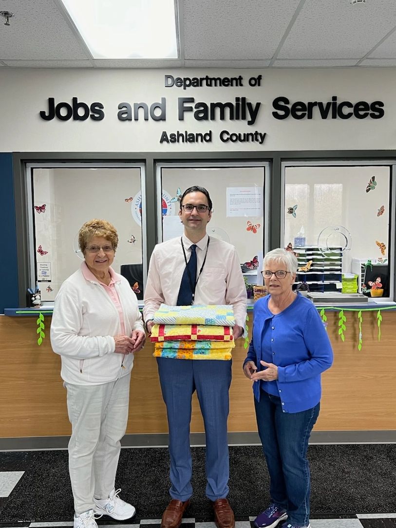 Nancy Boyd & Lana  Potter delivering donation quilts to Peter Stefanik at Jobs and Family Services.