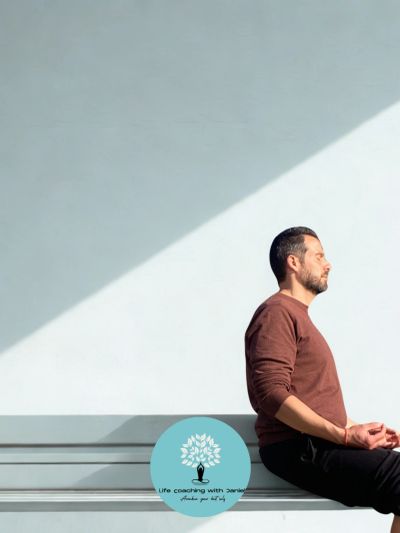 Homme méditant assis sur un banc sous une lumière douce.