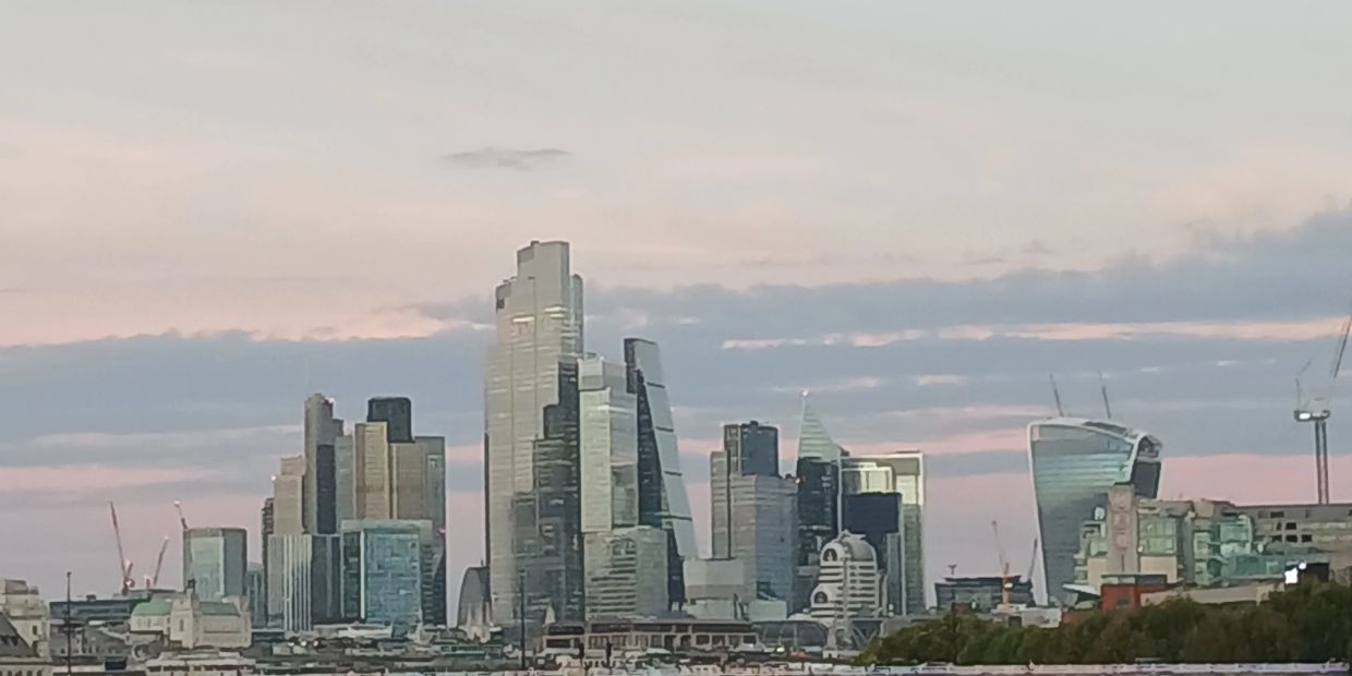 City skyline with modern skyscrapers under a pastel sky.