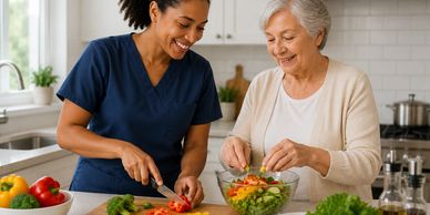 Caregiver and elderly woman preparing a fresh salad together in a kitchen.