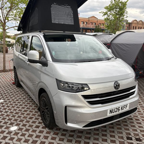 Silver Volkswagen camper van with pop-up roof.