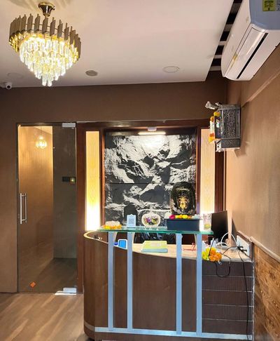 Elegant reception area with chandelier, glass door, and decorative Buddha statue.