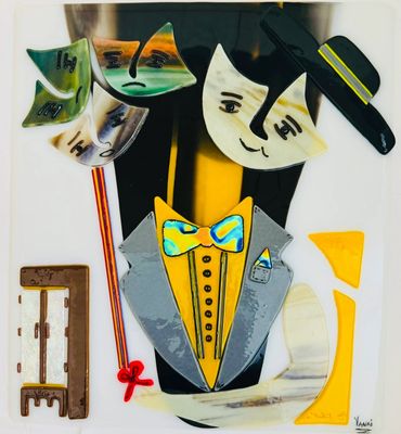Artistic fused glass sculpture of a cat in formal attire with a bow tie and hat.
