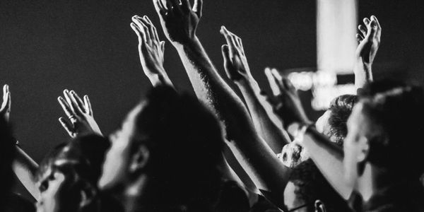 Crowd of people putting their hands in the air