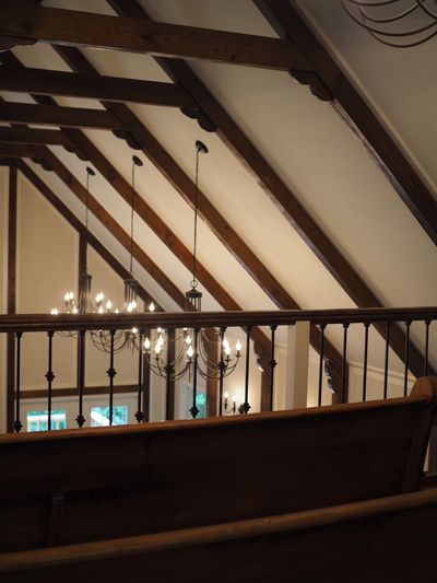 Interior of a room with wooden beams and chandeliers.