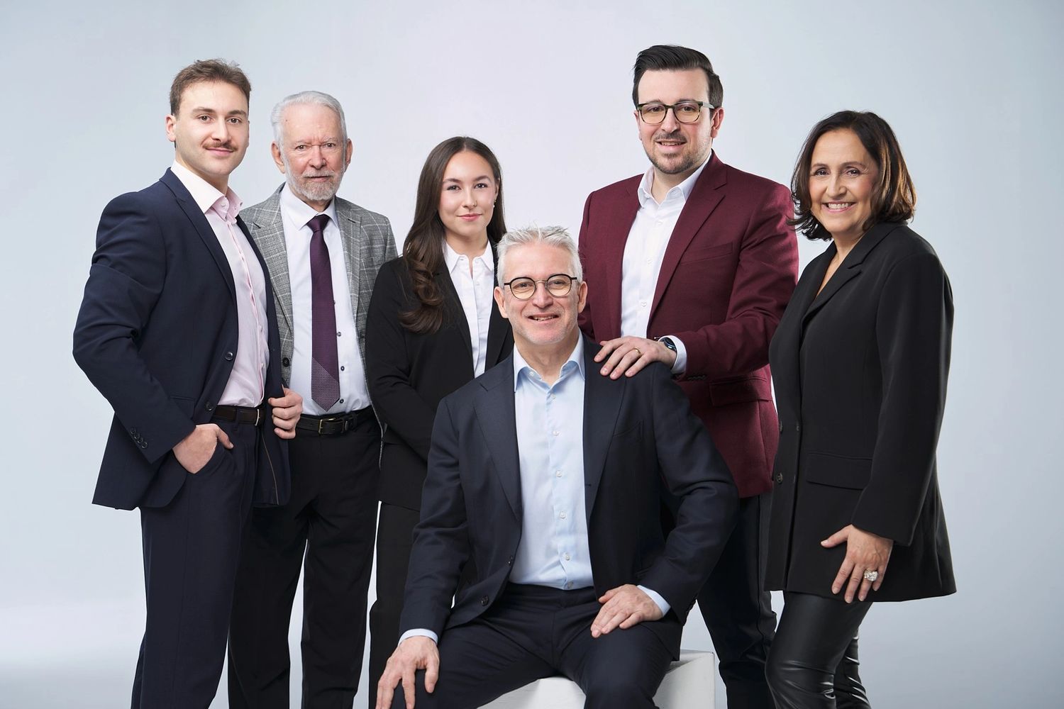 Stack of books next to pencils in a holder and a camera.