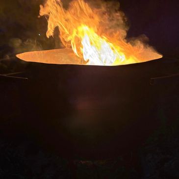 A large flame burning brightly in a dark setting.