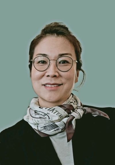 Smiling woman with glasses and scarf.