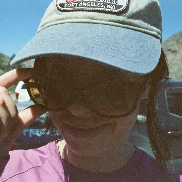 Person wearing a green cap and sunglasses.