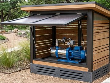 Water pump housed in a wooden and metal enclosure outdoors.