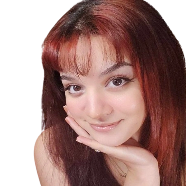 Young woman with red hair smiling gently, resting her face on her hand.