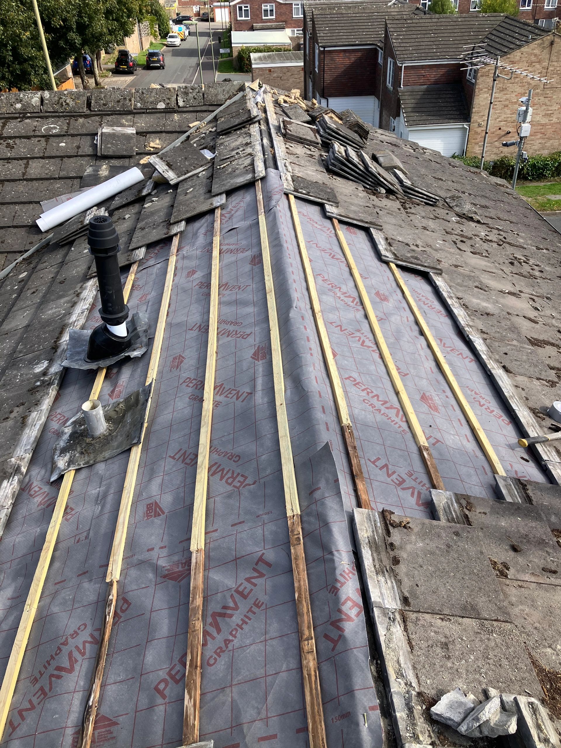 Lift and relay roof refurbishment in progress, with new breathable felt and treated battens installed before the existing tiles are carefully refitted.