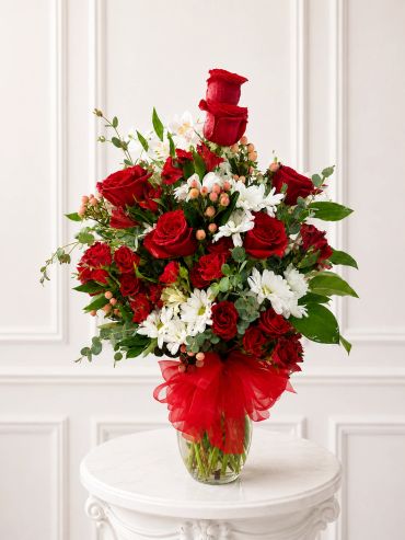 Bright orange and yellow floral arrangement in a gray vase.
