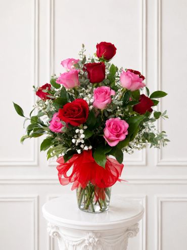 Elegant bouquet of red and pink roses with greenery.