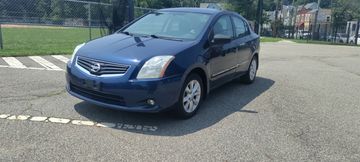 Blue Nissan sedan parked in a lot.