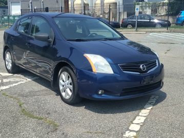Blue Nissan sedan parked in a lot.