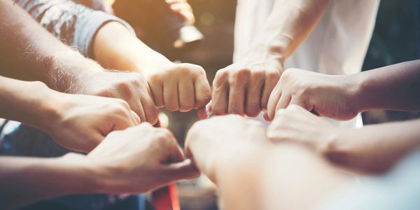 Group of hands bumping fists in unity.
