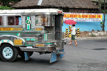 A pedestrian walks by a Jeepney 