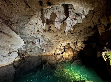 A serene underground cave pool illuminated by soft light.