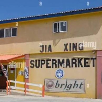 Exterior of Jia Xing Supermarket with yellow walls and bold signage.