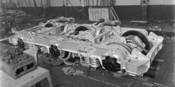 A large metal railway bogie frame in a workshop.