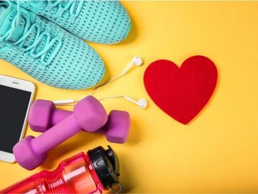 Sneakers, weights, water bottle and cellphone showcasing items needed for a workout