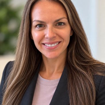 Smiling woman with long hair in professional attire.