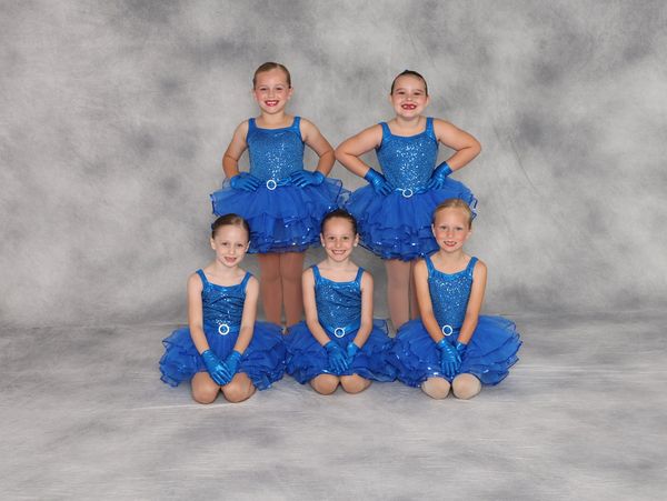 Young girls in blue dance costumes posing.